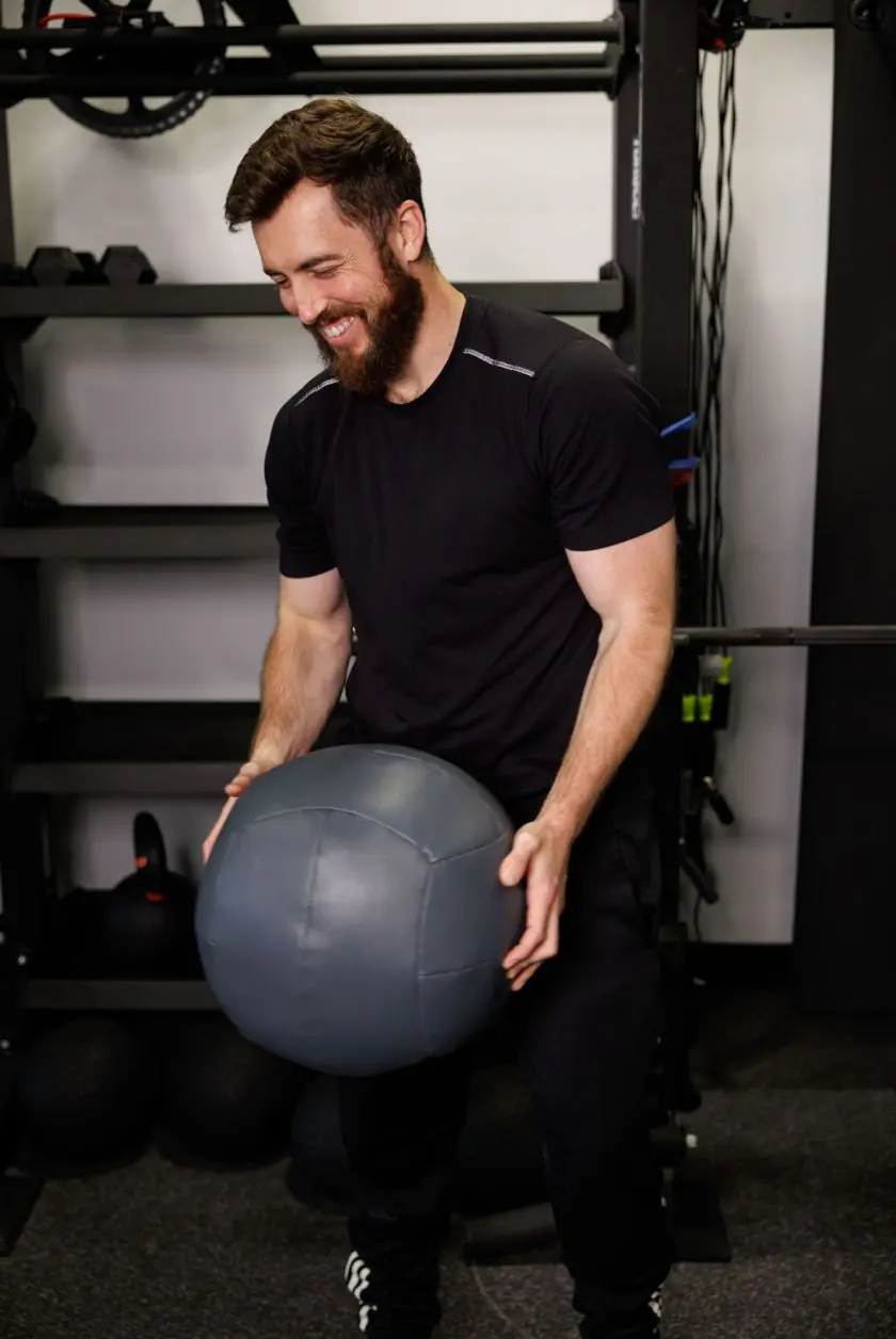 Trainer Terry laughing while lifting a medicine ball